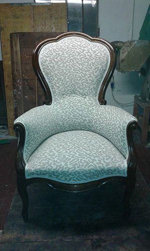 una poltrona in legno con cuscini di color grigio