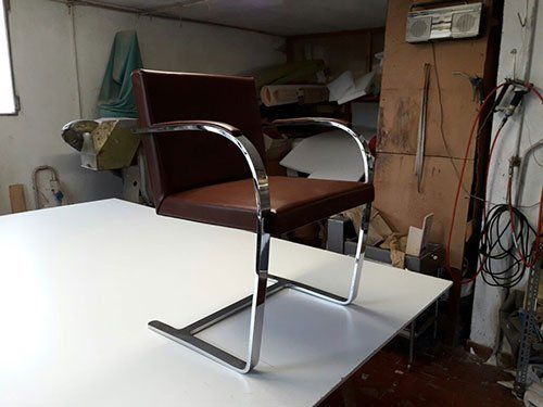 una sedia con cuscini in pelle e una struttura in acciaio inox