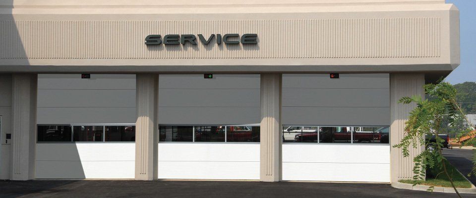 Exterior of a service center with three closed garage doors. 