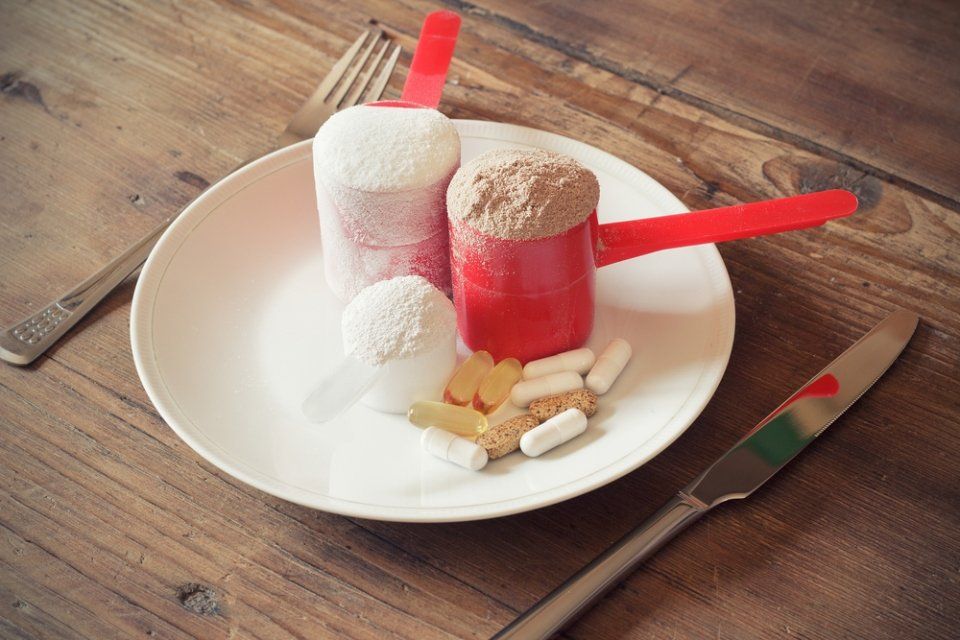 piatto con integratori alimentari in pillole e polvere