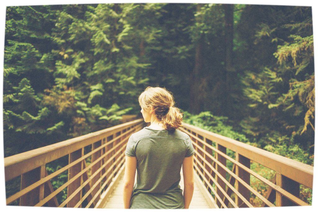 Woman walking along bridge looking to side. Transition coaching for Doctors and Professionals