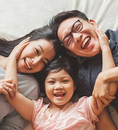 Happy Family Laying on Bed — Benton County Health Department — Warsaw, MO Happy Family Laying on Bed — Benton County Health Department — Warsaw, MO