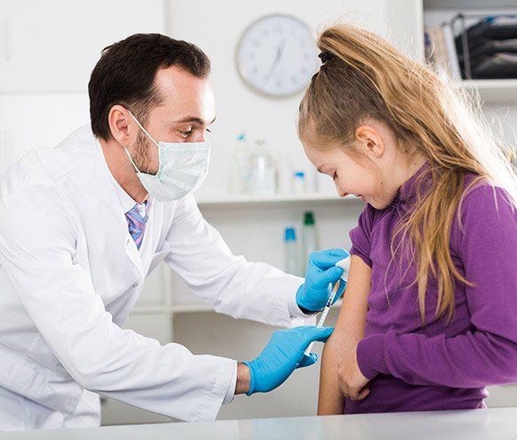 Male Doctor Injecting Little Patient — Benton County Health Department — Warsaw, MO Male Doctor Injecting Little Patient — Benton County Health Department — Warsaw, MO