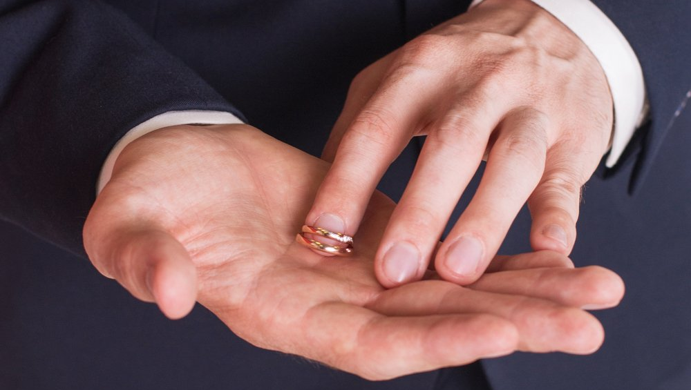 Man holding two wedding rings in his hands