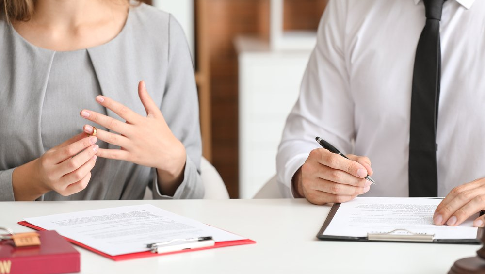 Couple in a Divorce Office signing paperwork