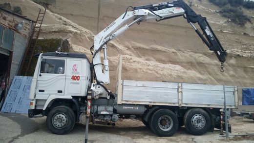 camion con gru lavora in un cantiere edile