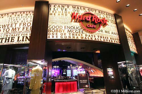 Hard Rock Cafe entrance with logo above, memorabilia displays, and lyrics on the wall.