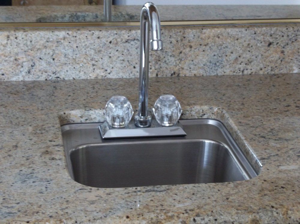 Installed wet bar countertop with sink and stone backsplash