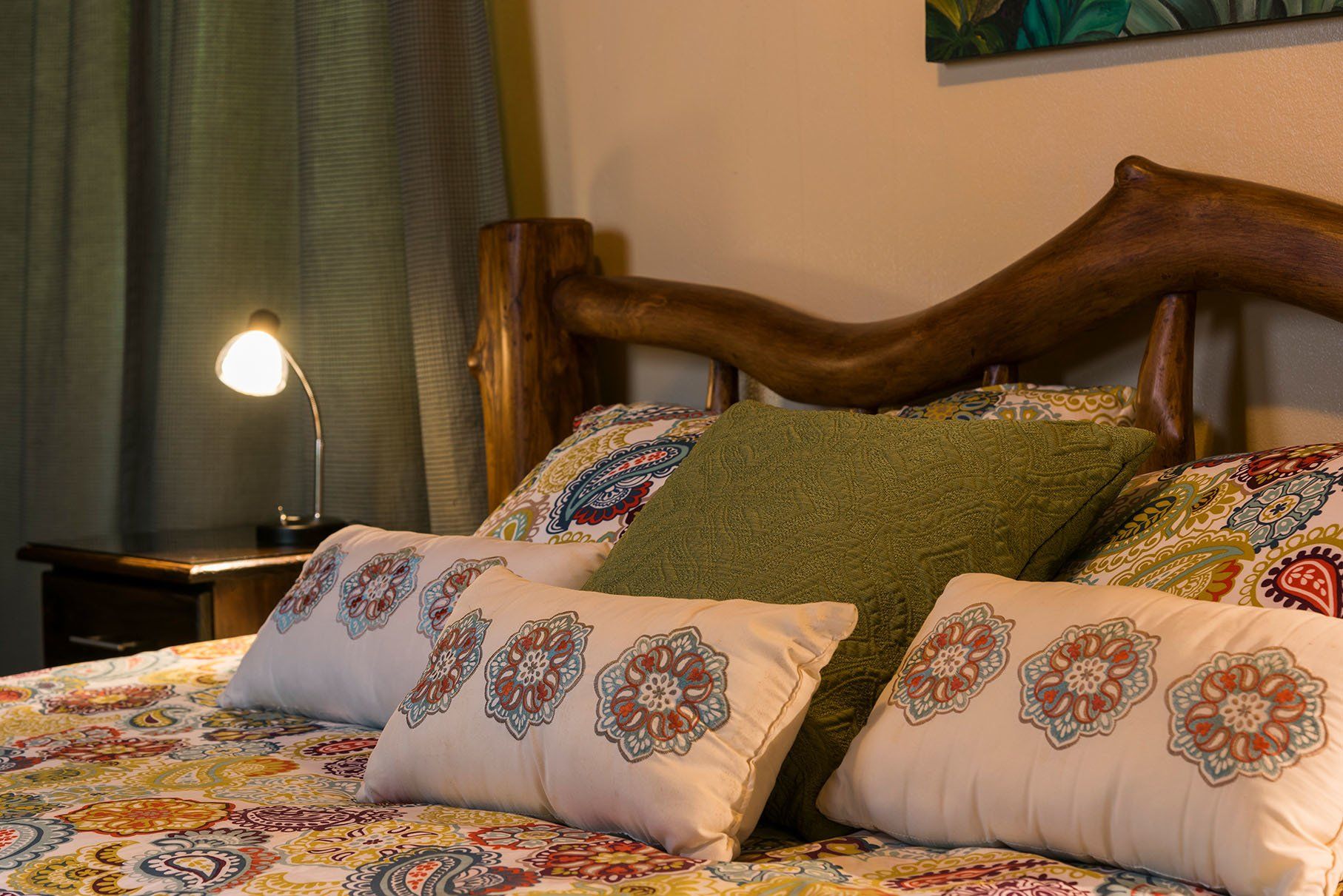 a bed with a wooden headboard and pillows in a bedroom .