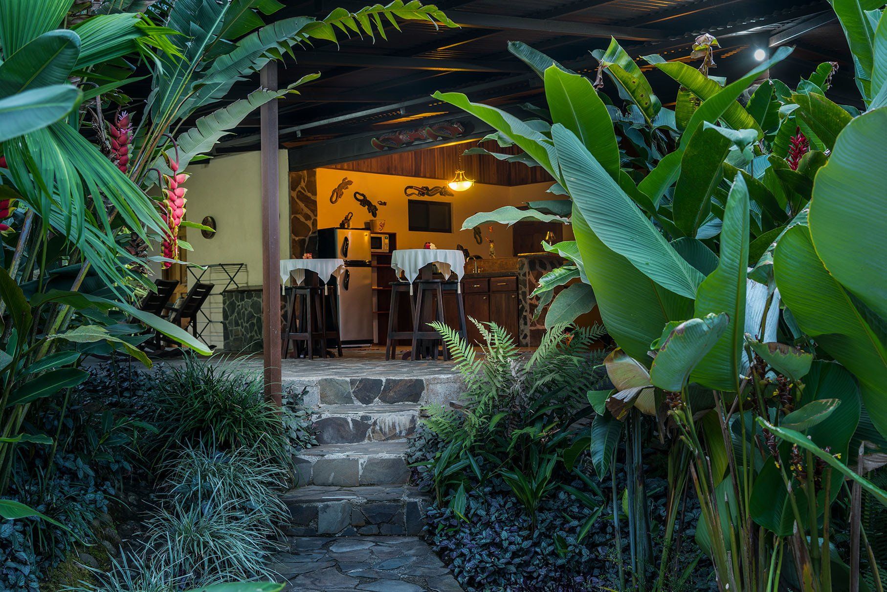 a restaurant is surrounded by lots of plants and flowers .
