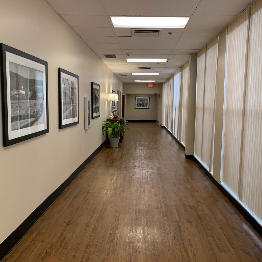 A long hallway with a lot of windows and pictures on the wall