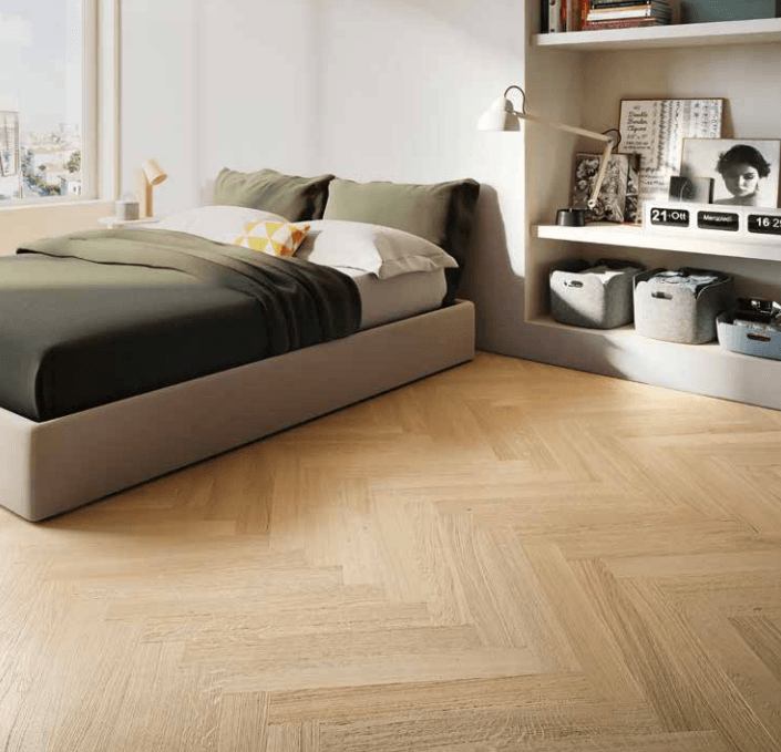 Camera da letto moderna con letto basso, pavimento in legno a spina di pesce e scaffalature a muro con cestini portaoggetti.