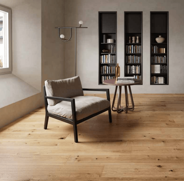 Soggiorno minimalista con poltrona beige, tavolino e mensole a muro integrate con libri.