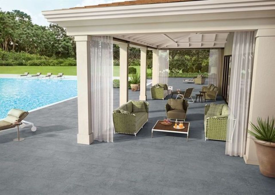 Patio coperto con posti a sedere e braciere accanto alla piscina nel giardino.