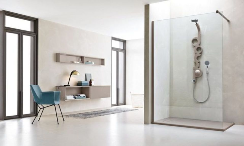 Bagno moderno con doccia in vetro, pareti bianche e sedia color verde acqua accanto a una mensola a muro.