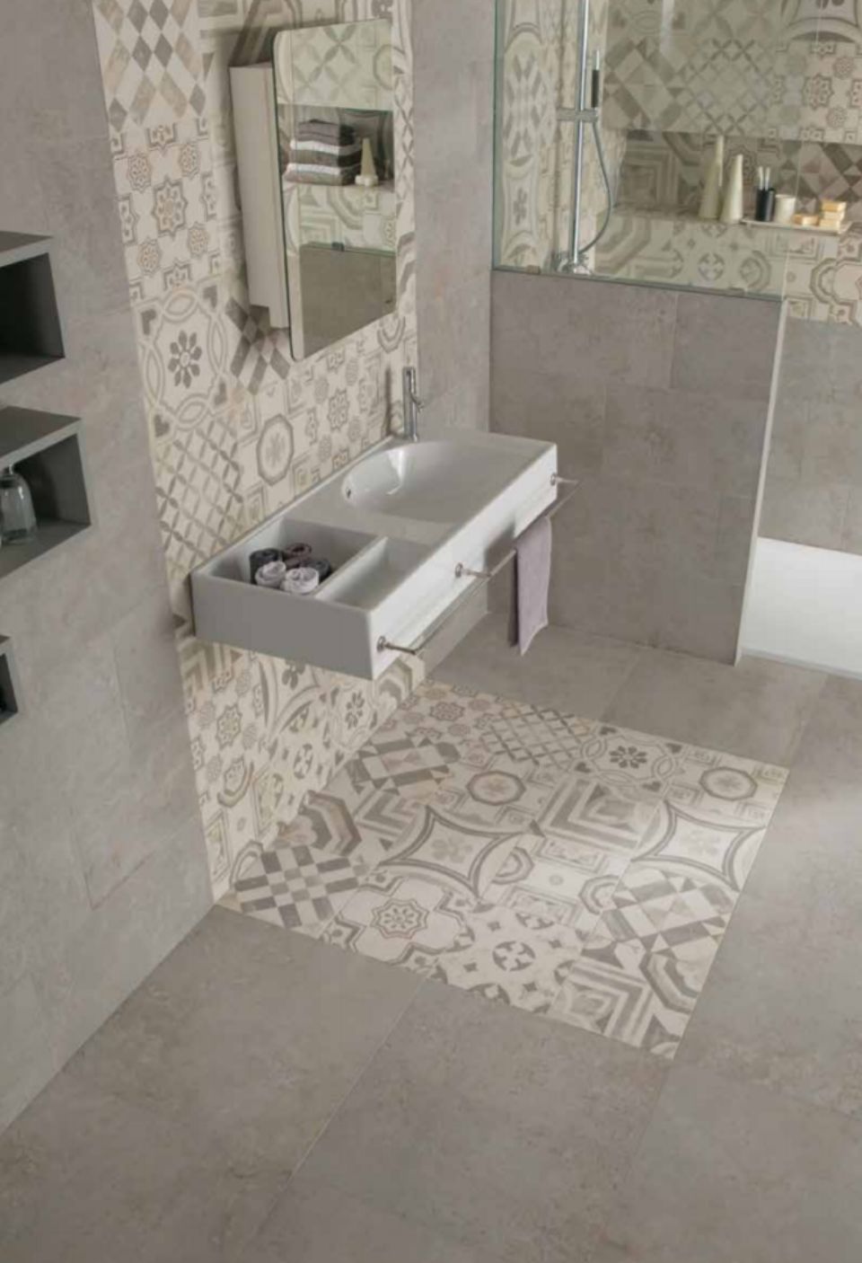 Bagno moderno con piastrelle decorate, lavabo a parete, specchio e cabina doccia.