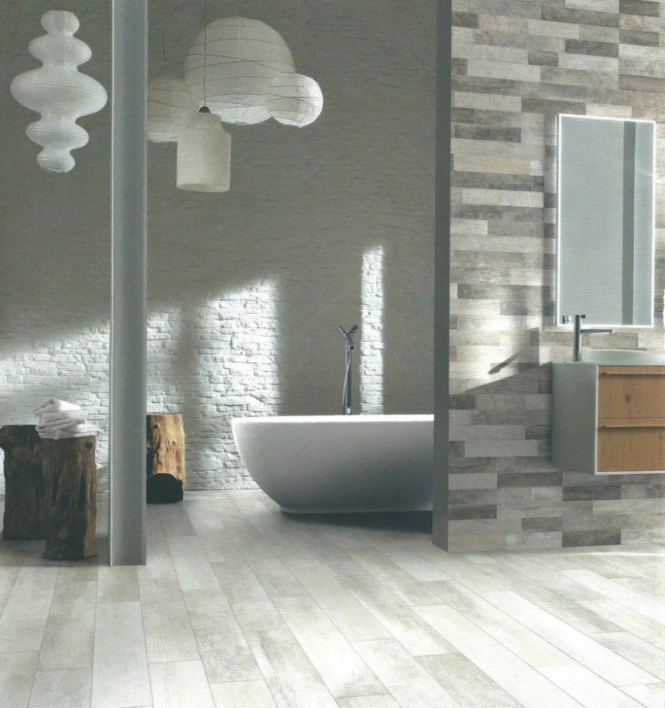 Bagno moderno e minimalista con vasca freestanding, pareti in pietra e lampade a sospensione.