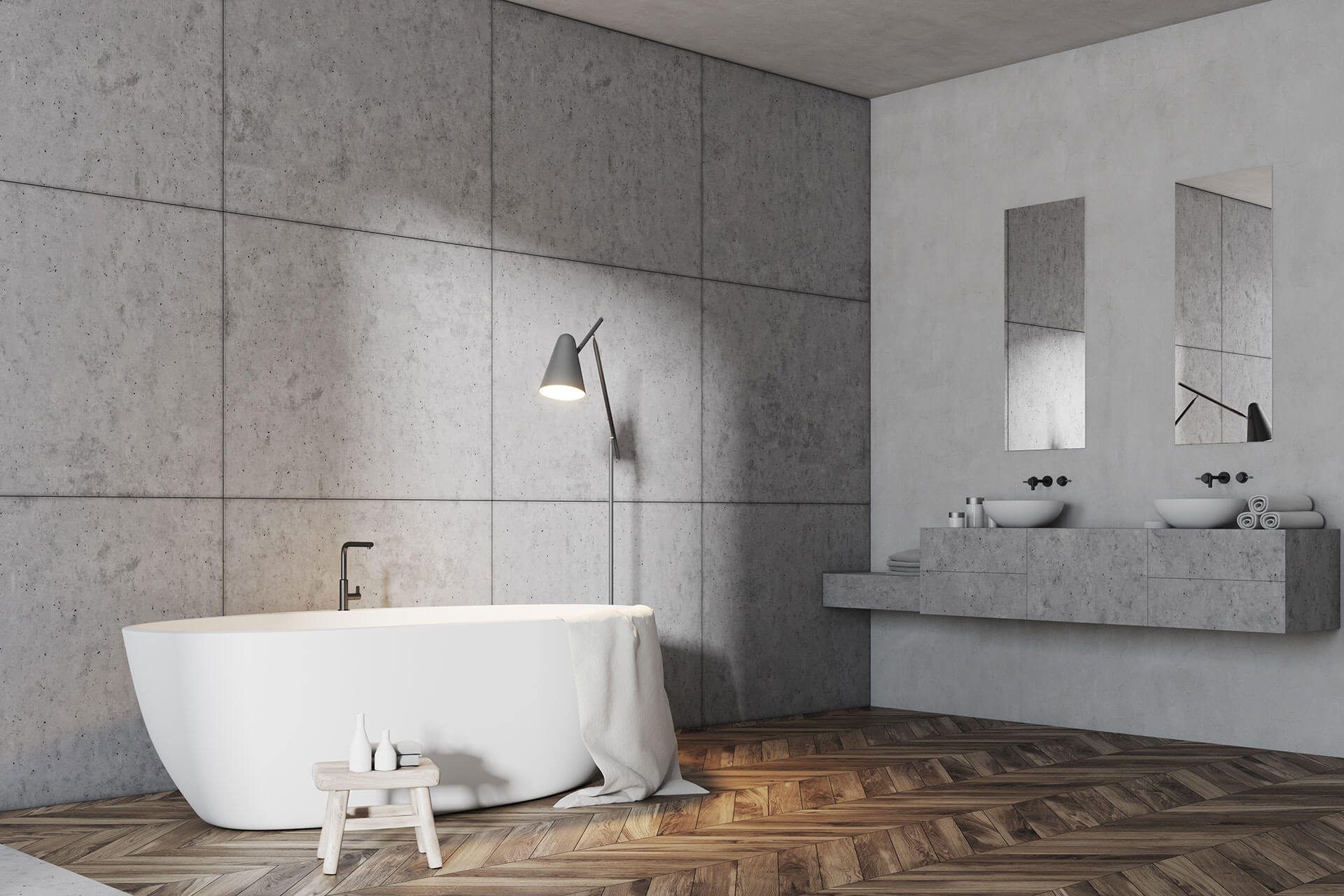 Bagno moderno e minimalista con vasca bianca, pareti rivestite con piastrelle grigie, mobile lavabo e pavimento in parquet a spina di pesce.