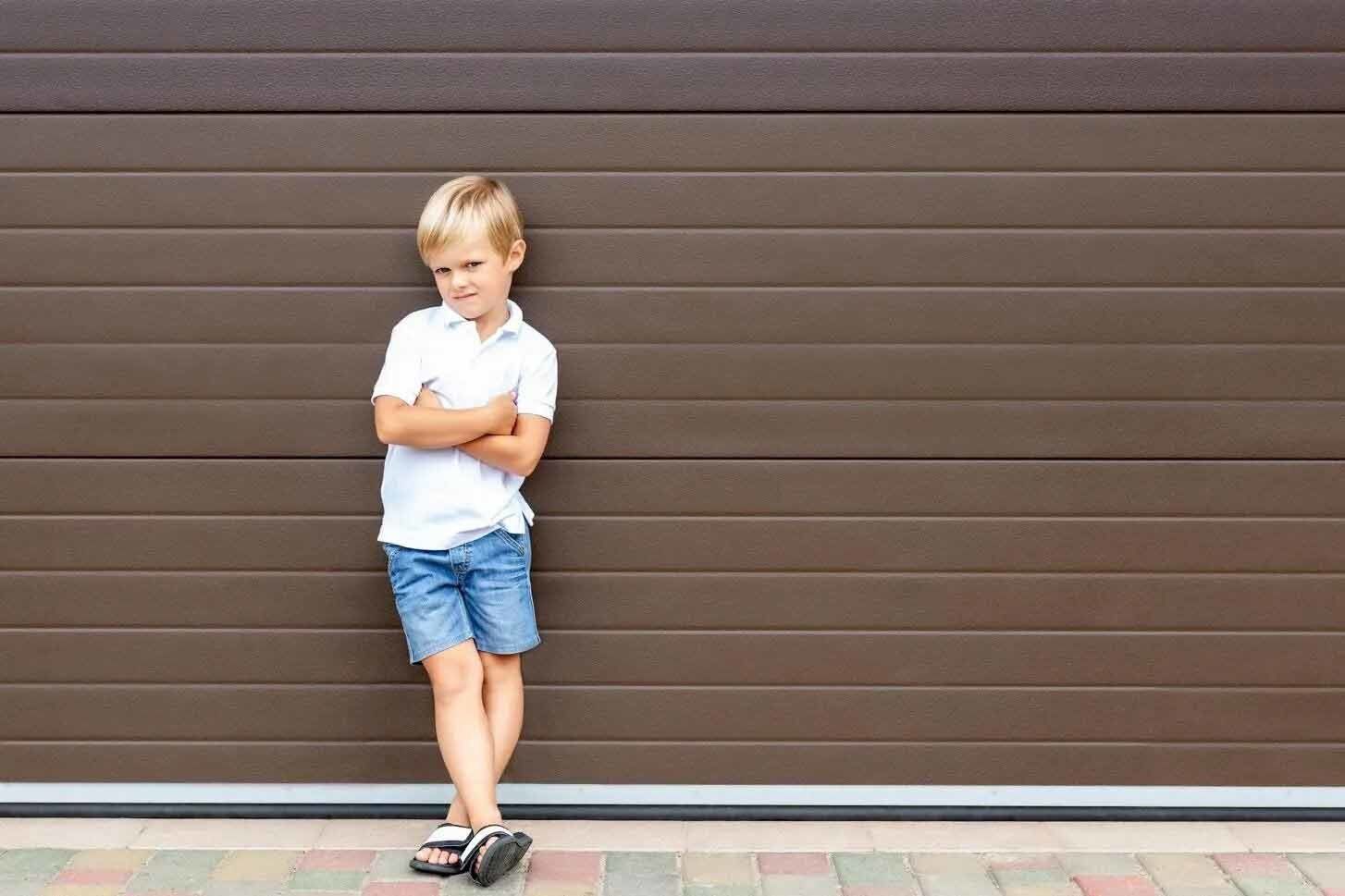Maintenance — Boy Standing in Front of Garage Door in Signal Hill, CA Maintenance — Boy Standing in Front of Garage Door in Signal Hill, CA