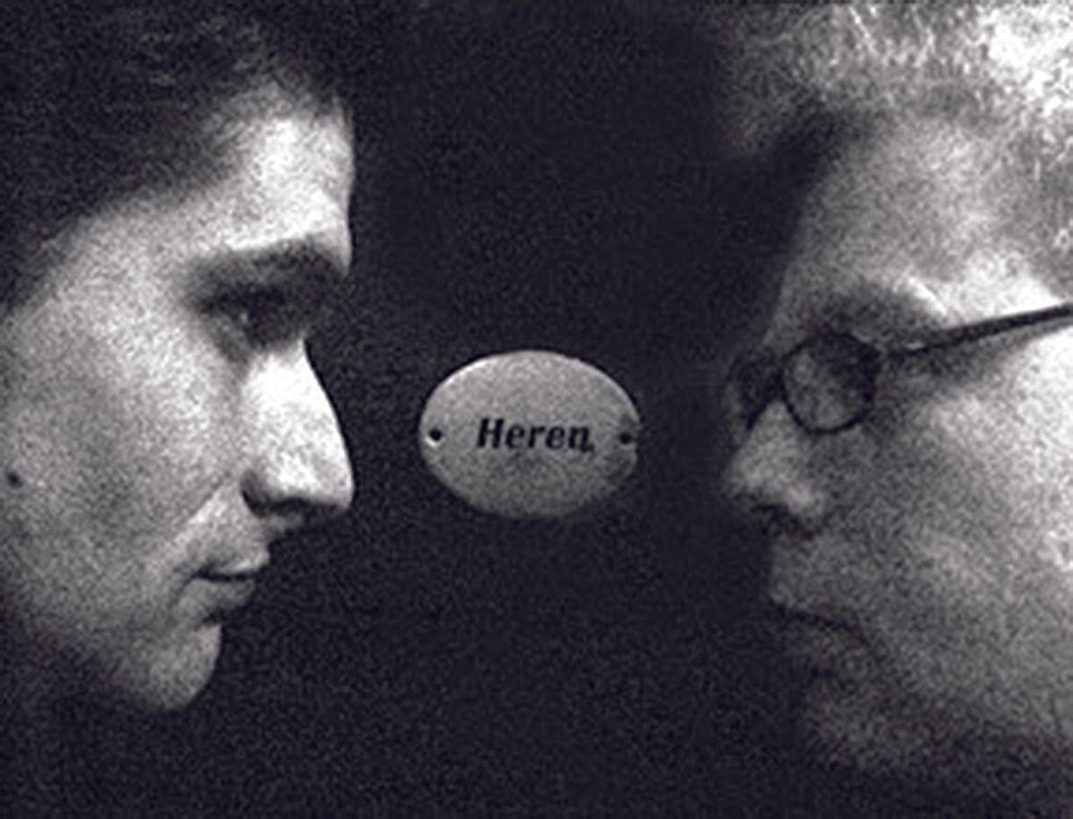Two men face each other in profile with a gray ball labeled “Herea” between them.