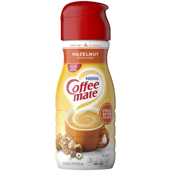 A plastic bottle of Nestlé Coffee mate Hazelnut coffee creamer with a red cap and brown, cream, and orange branding.