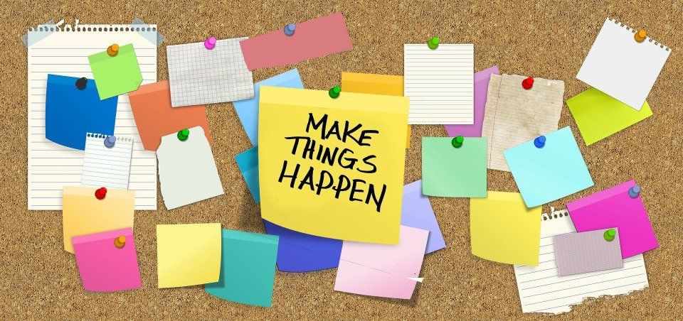 Corkboard with colorful sticky notes, the central one reading