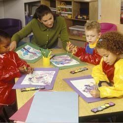 Teacher Helping Children Do Homework at Daycare | Goffstown, NH | Educare Daycare & Learning Center Teacher Helping Children Do Homework at Daycare | Goffstown, NH | Educare Daycare & Learning Center
