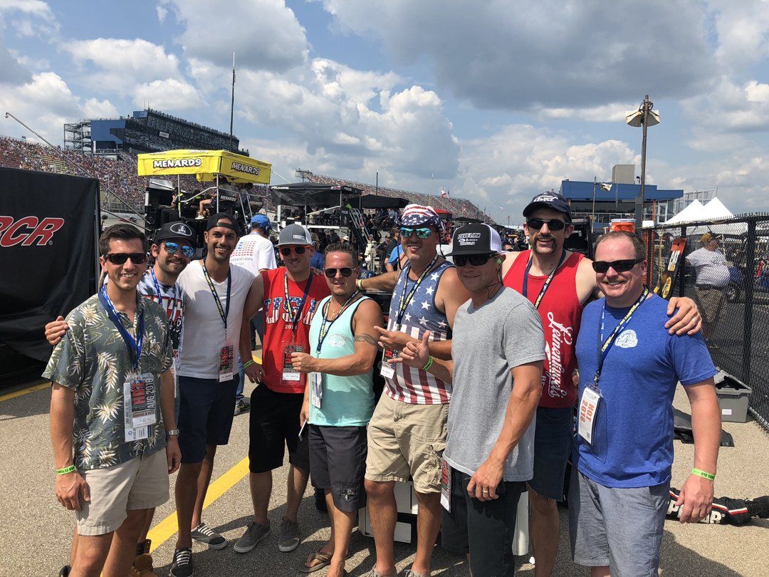 A group of people are posing for a picture at a race track.