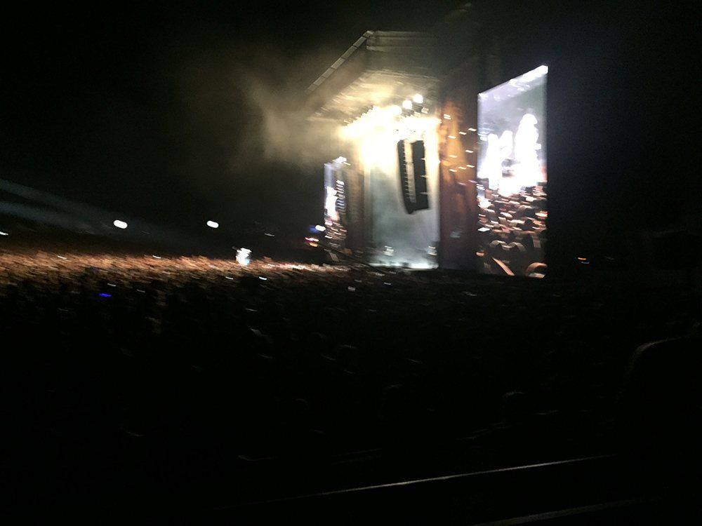 A crowd of people watching a concert in the dark