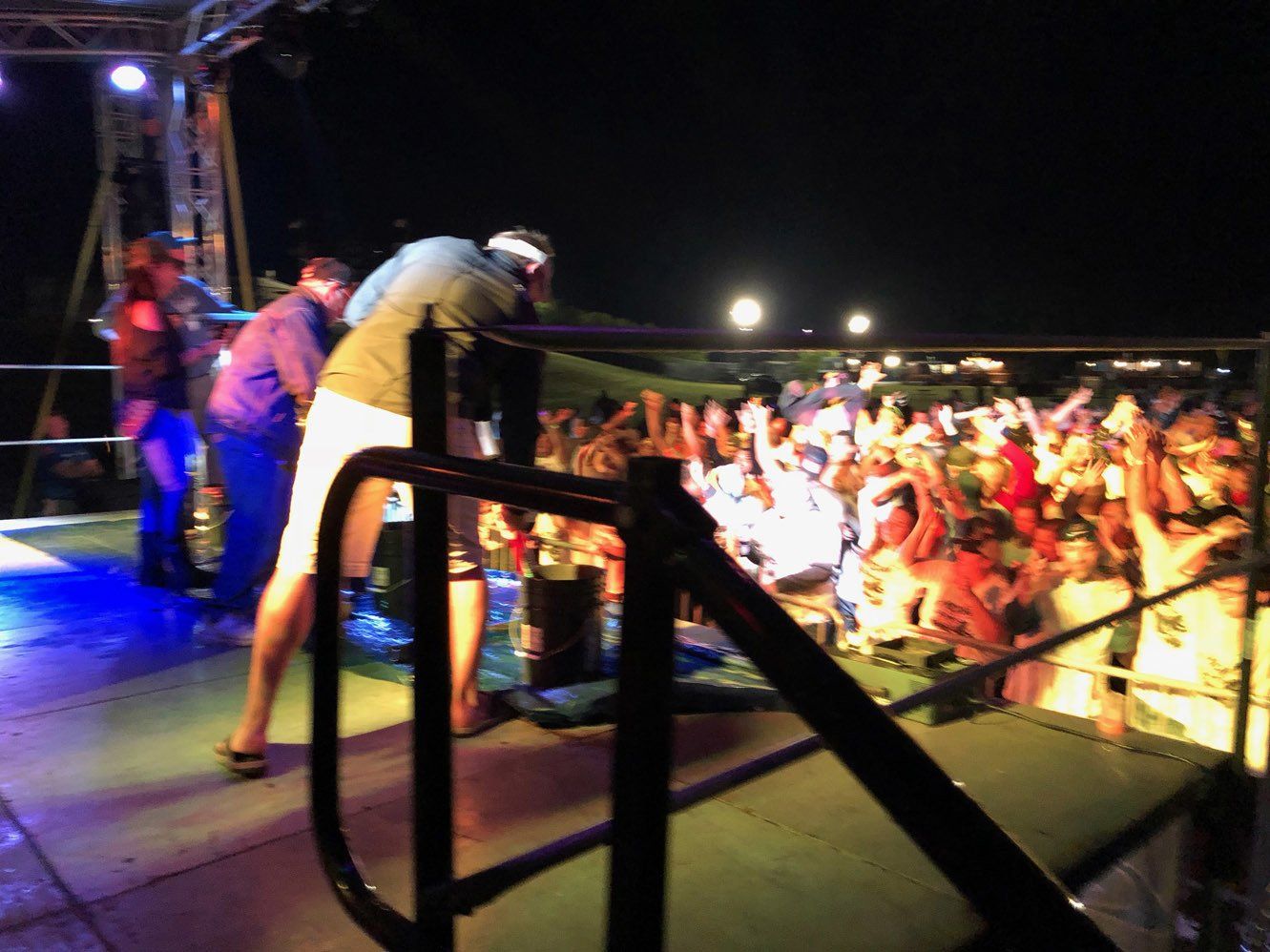 A group of people are standing on a stage at night