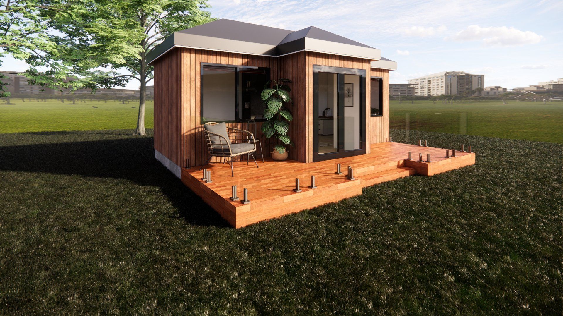 A small wooden house with a deck in the middle of a field.