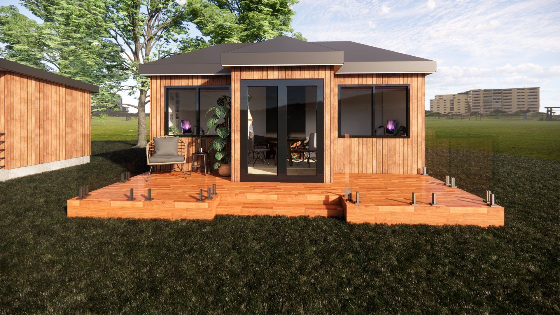 A small house with a wooden deck in the middle of a field.