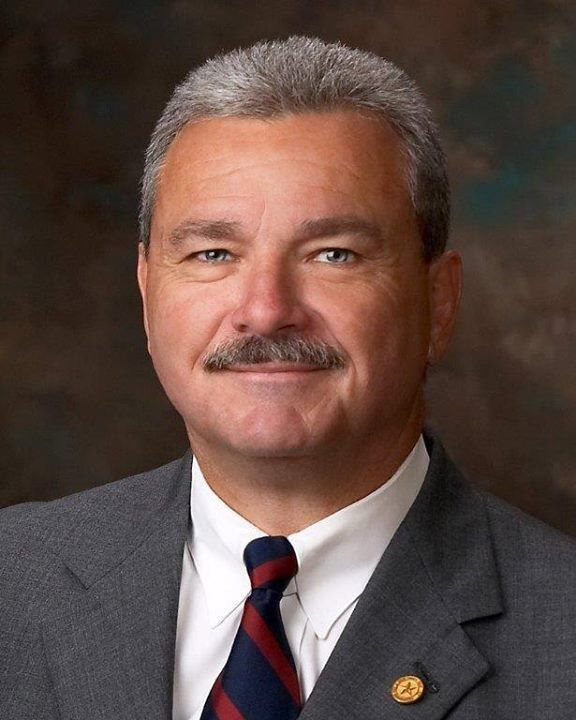 A man with a mustache is wearing a suit and tie