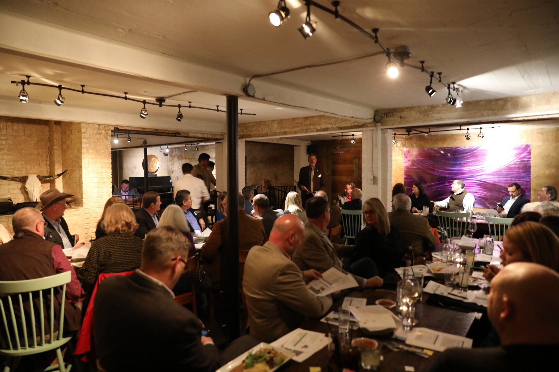 A group of people are sitting at tables in a restaurant.