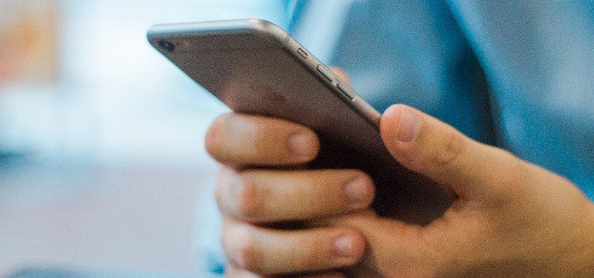 A person is holding a cell phone in their hand.