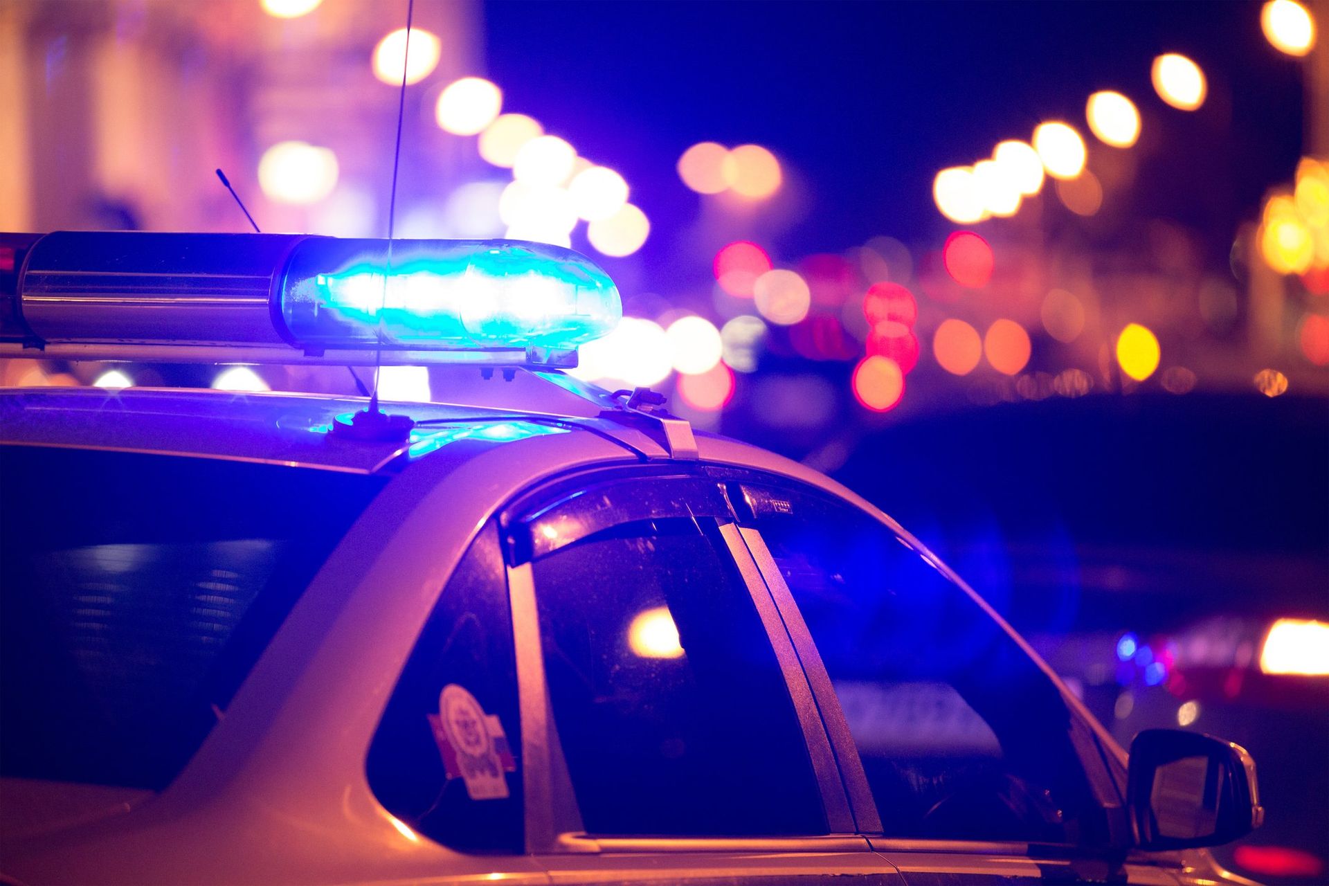 A police car with blue lights on top of it at night.