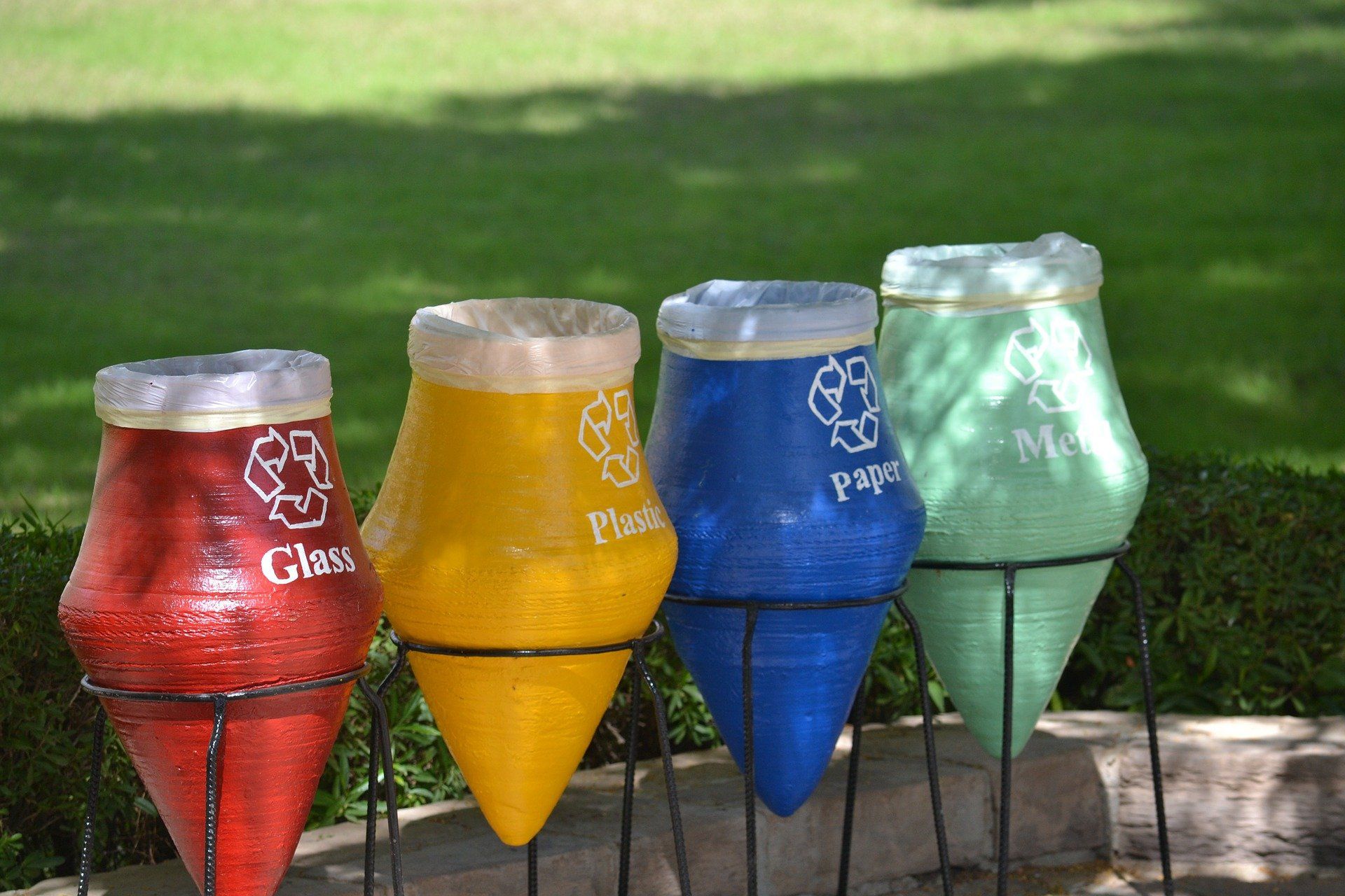 A row of recycling bins with one that says glass on it