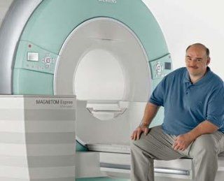 Uomo con maglietta blu accanto a dispositivo diagnostico