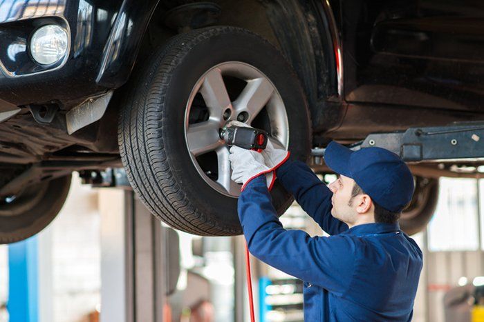 Auto Inspections — Man Fixing the Wheel Alignment in Erie, PA