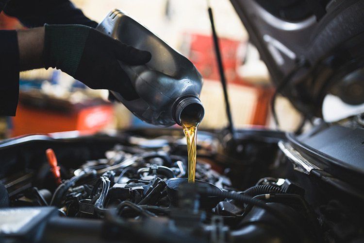 Oil Changes — Pouring Oil into Engine Motor in Erie, PA Oil Changes — Pouring Oil into Engine Motor in Erie, PA