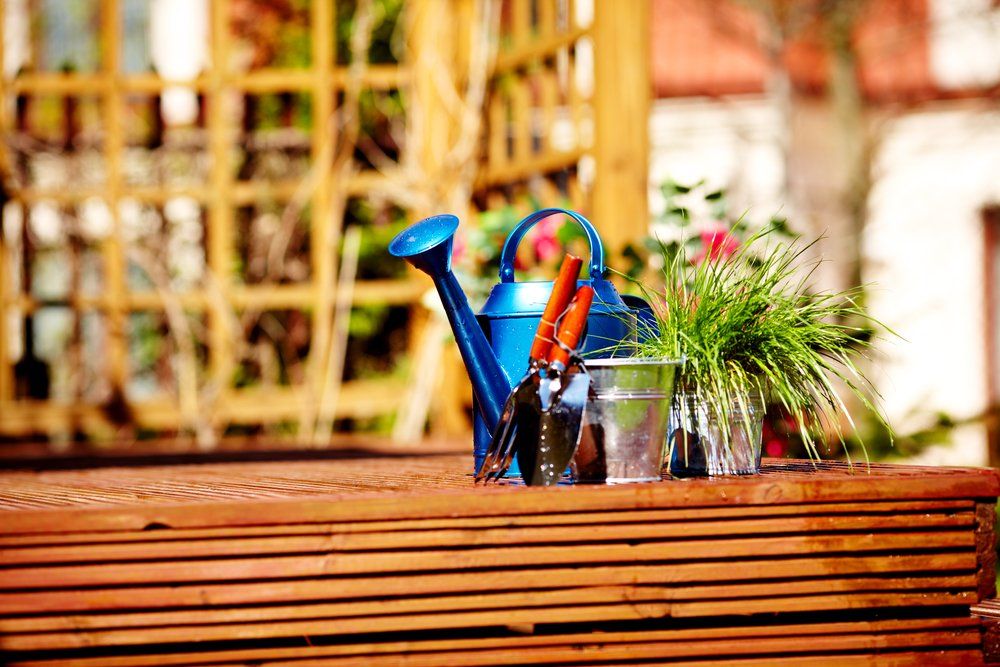 Watering can with flowers on a front porch