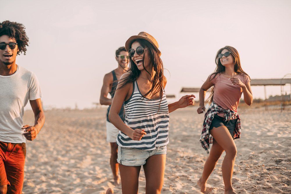 Junge Gruppe Menschen hat eine aufhellende Stimmung am Strand