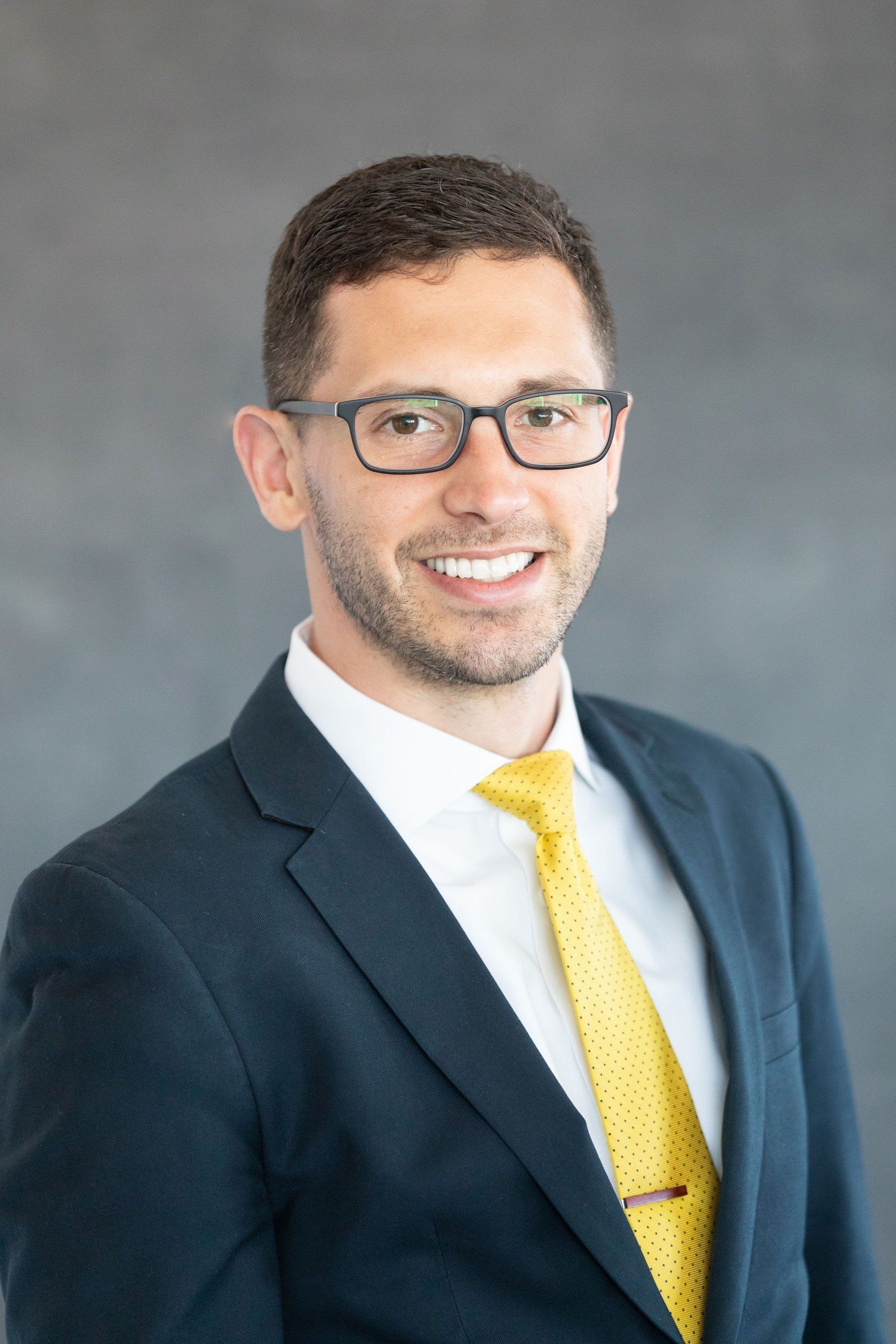 A man in a suit and tie is smiling for the camera.
