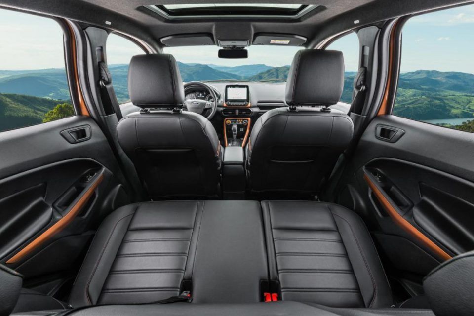 O interior de um ford ecosport com o porta-malas aberto e montanhas ao fundo.