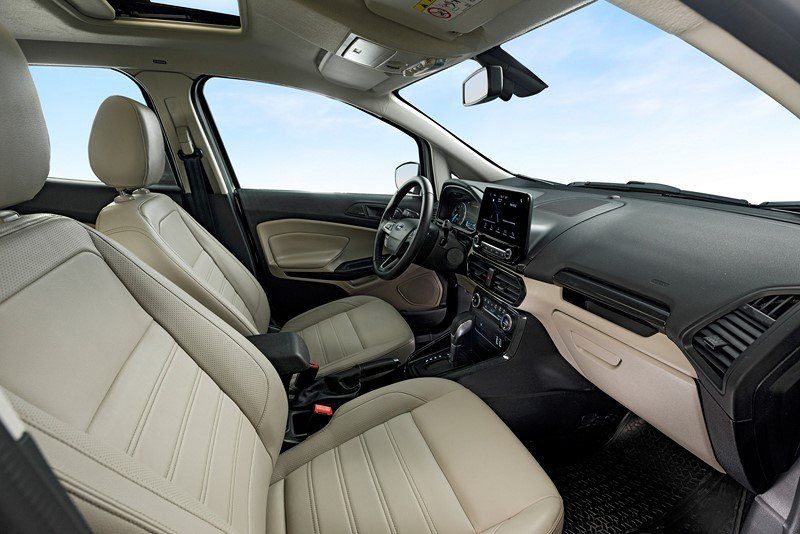 O interior de um carro com bancos de couro bege e teto solar.