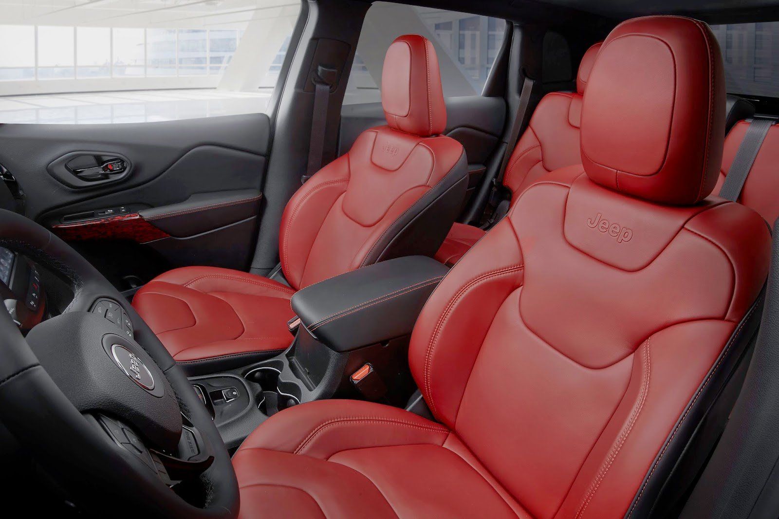 O interior de um jipe cherokee com bancos de couro vermelho.