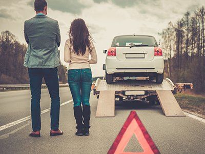 automobilisti in strada mentre l'auto viene trasportata in officina