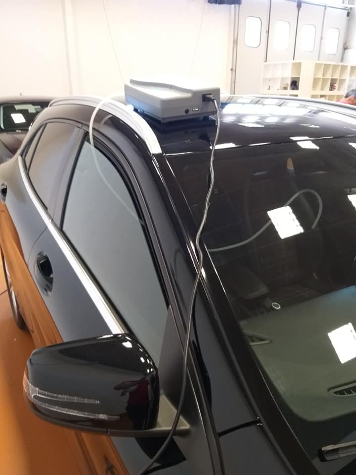 carrozziere in officina durante la lucidatura di una vettura