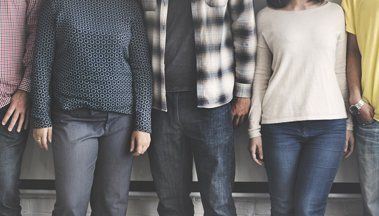 A group of people are standing next to each other in a line.