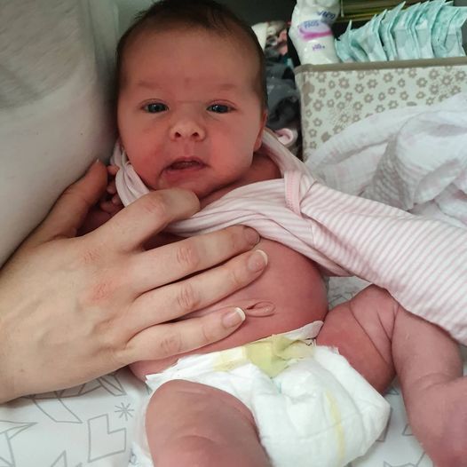 A baby in a diaper is being held by a person